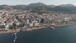 D-Log M. Marmaris, Turkey. Beachfront hospitality scene with sun loungers, calm water and promena...