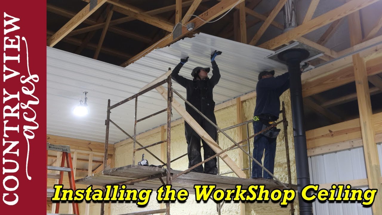 Using a rolling scaffold to install the 14 foot high metal Ceiling in