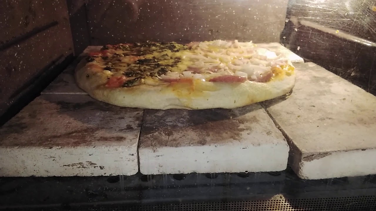 Pizza na pedra refratária no forno elétrico cuidando a temperatura superior a 200°... Perfeito!
