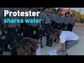 See protesters donating water to police and thanking them