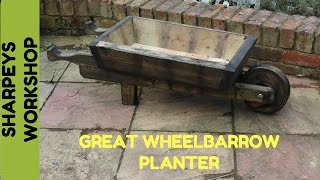 I made this wheelbarrow planter from some old decking supports and pallet wood for the base as usual stained it with old engine oil 