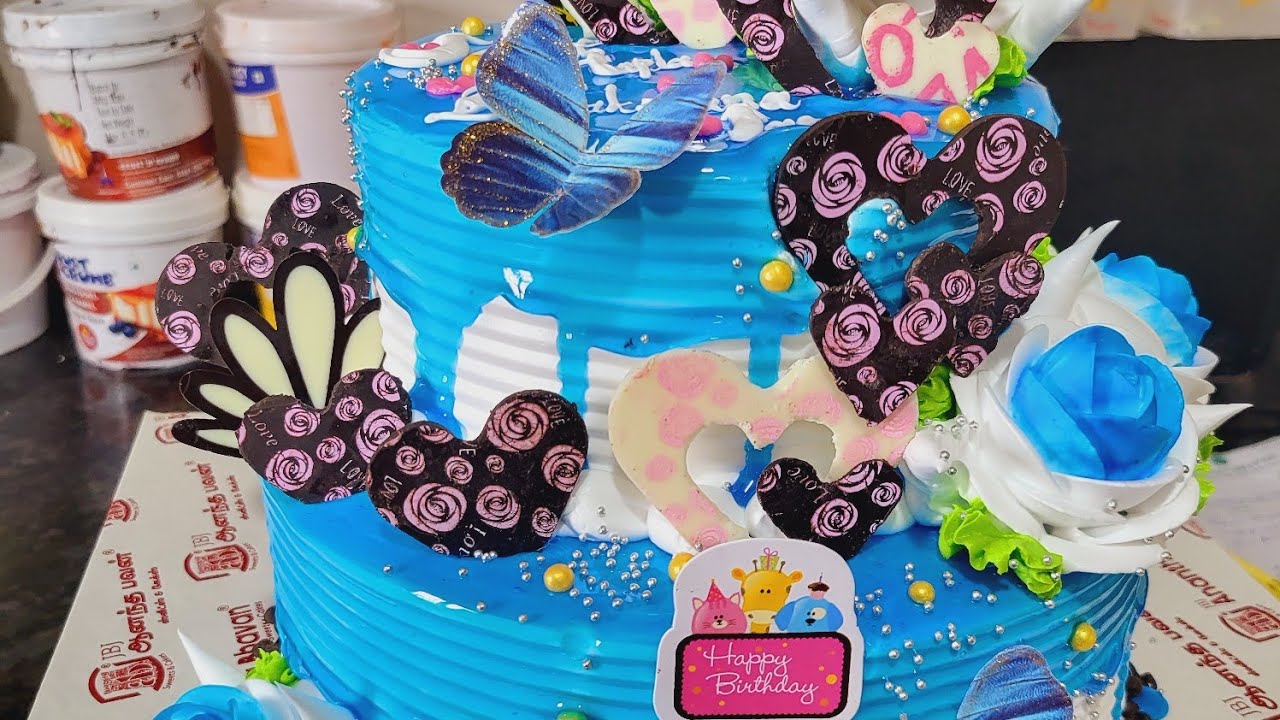 2 tier cake blue jel icing black forest   chocolate garnish desgin 