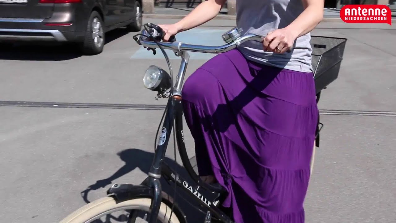 frau fliegt beim fahrrad fahren der rock hoch