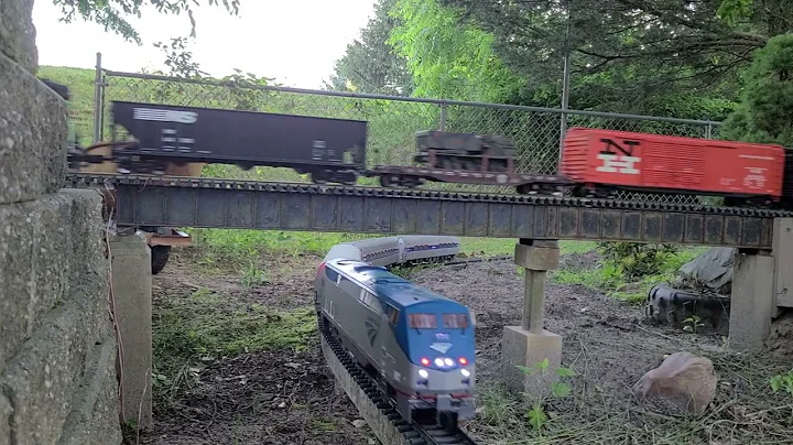 LGB Amtrak train passing under a Mixed freight.