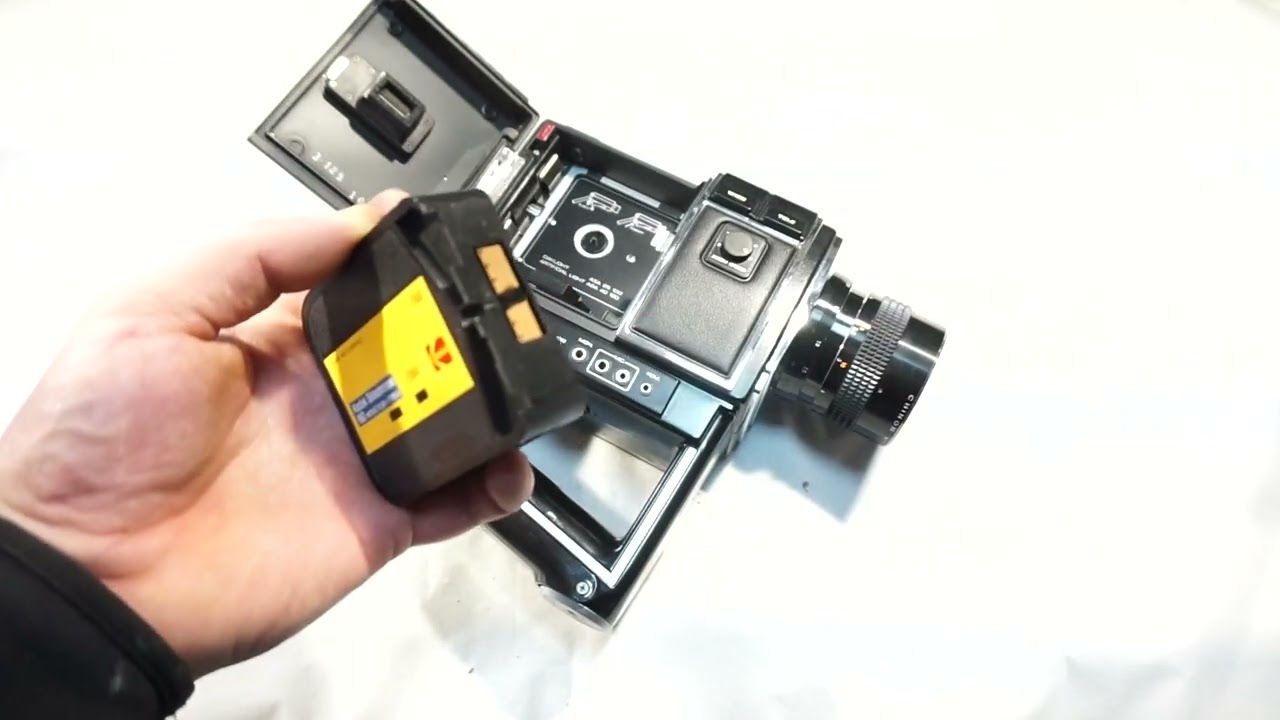 Canon 814 loading Super 8 film and batteries on Super 8 camera