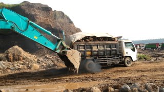 Excavator Helps a Loaded Truck that is stuck in Muddy Ground