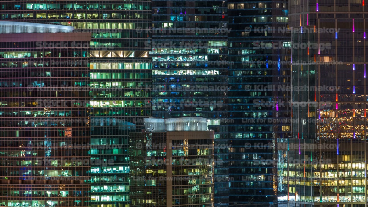 Modern office building with glowing windows at night timelapse. Moscow city