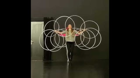 Two Women Make Hypnotic Moving Shapes With Several Hula Hoops - 1099914
