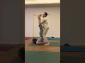 Yoga teacher helps students practice folding their body