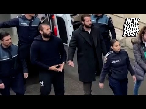 Andrew Tate flashes hand symbol as he’s led handcuffed into court | New York Post