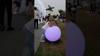 Toddler enjoys light-changing color ball display at Blue Bay Walk Park, Pasay City