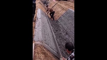 Making concrete drainage ditch with skilled construction workers