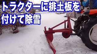 トラクターに排土板をつけて除雪