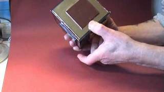 A metallic-looking puzzle box, with a sliding panel on each side.