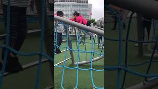 Girl climbs monkey barsat playground then falls and lands awkwardly