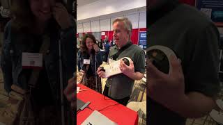 A visitor to the CSUN Booth plays Arcana Strum like a guitar