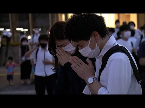 People lay flowers, pay respects at Abe murder scene