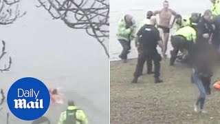 Moment hero police officer dives into freezing water to save man - Daily Mail