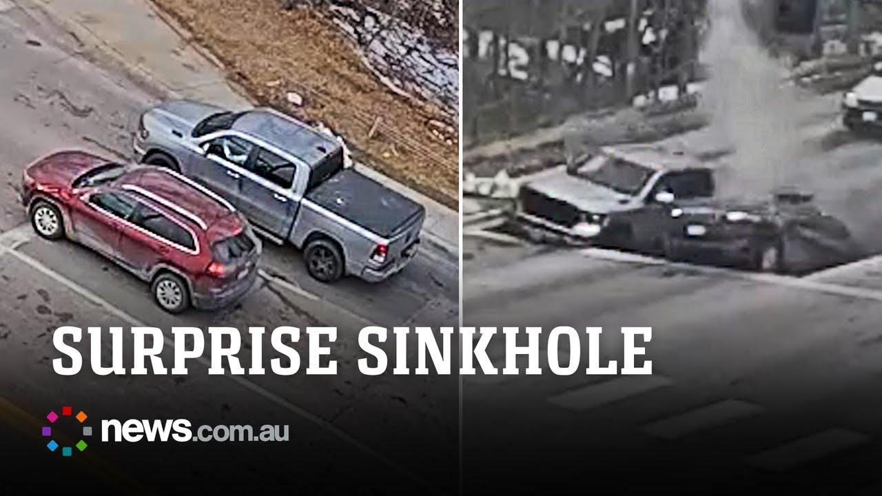 Two cars fall into sinkhole at traffic light