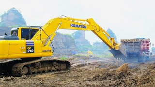 Excavator Helps a Loaded Truck that is stuck in Muddy Ground