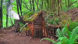 Building survival shelter with a fireplace. Bushcraft earth hut, moss roof & fireplace made of mud