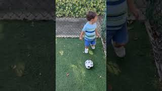 Boy kicks soccer ball around playground then runs into spring rider and bumps head