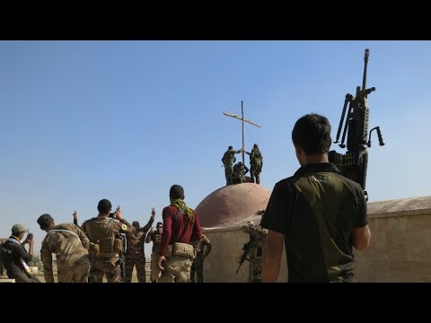 مقاتلون عراقيون يرفعون الصليب على كنيسة بعد استعادتها من الجهاديين