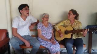 Senhora de 99 anos cantando com o neto e a filha - Encontro de Gerações