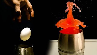 Dropping an egg into the colored water in slow motion