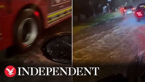 Cars splash through submerged roads as heavy flooding hits London
