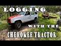 Logging with a Jeep.  Cherokee Tractor tugging and arching logs in the woods.