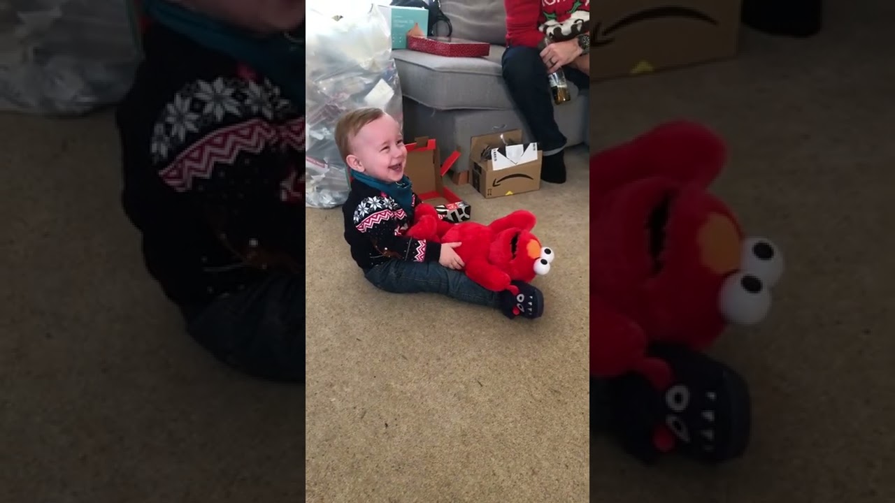 Belly laughing toddler with tickle me Elmo 
