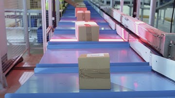 Parcels are moving on belt conveyor at post sorting office box pov