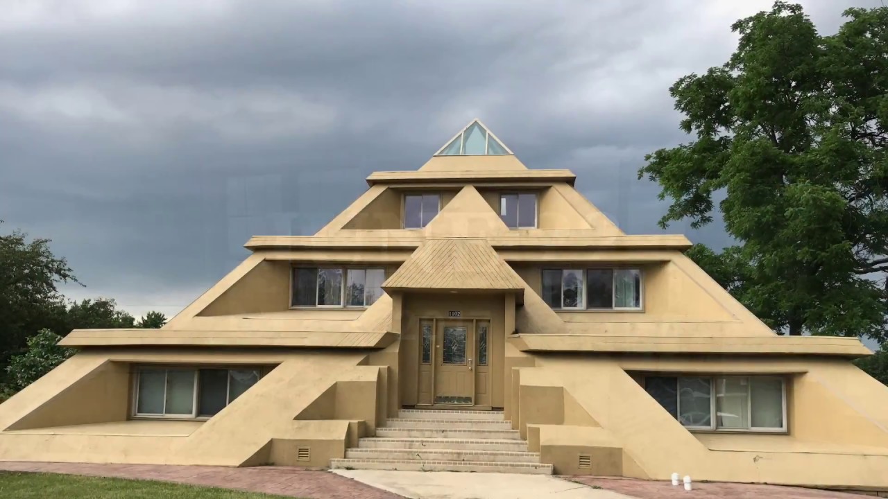 На фотографии виден жилой дом у которого крыша имеет форму пирамиды с ...