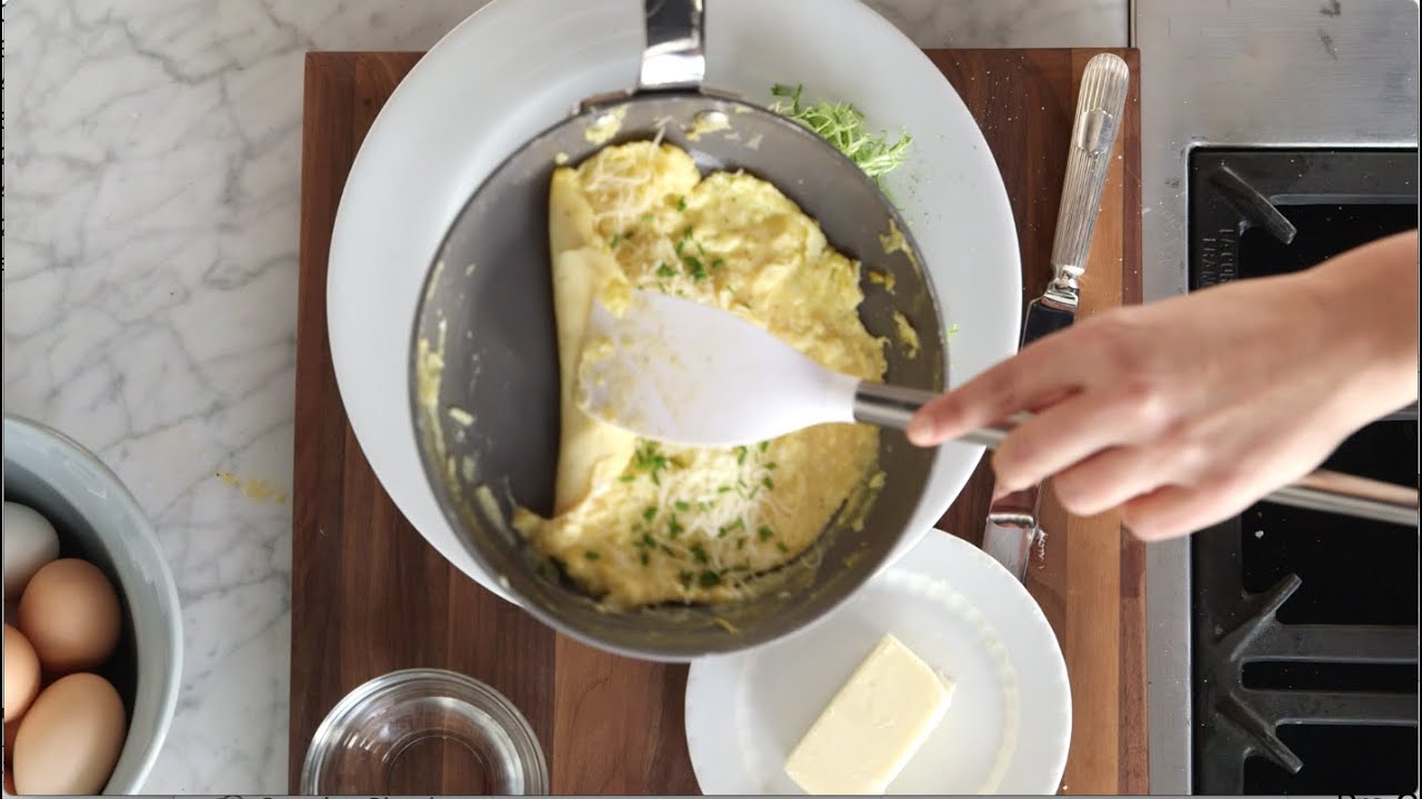 Close-up of a chef preparing a french omelette on a frying pan in