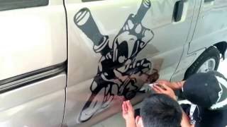 Pemasangan stiker gambar pada body mobil