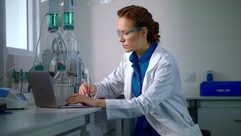Female Scientist Working in Laboratory. Lab Worker Typing Report on Computer  | Stock Footage