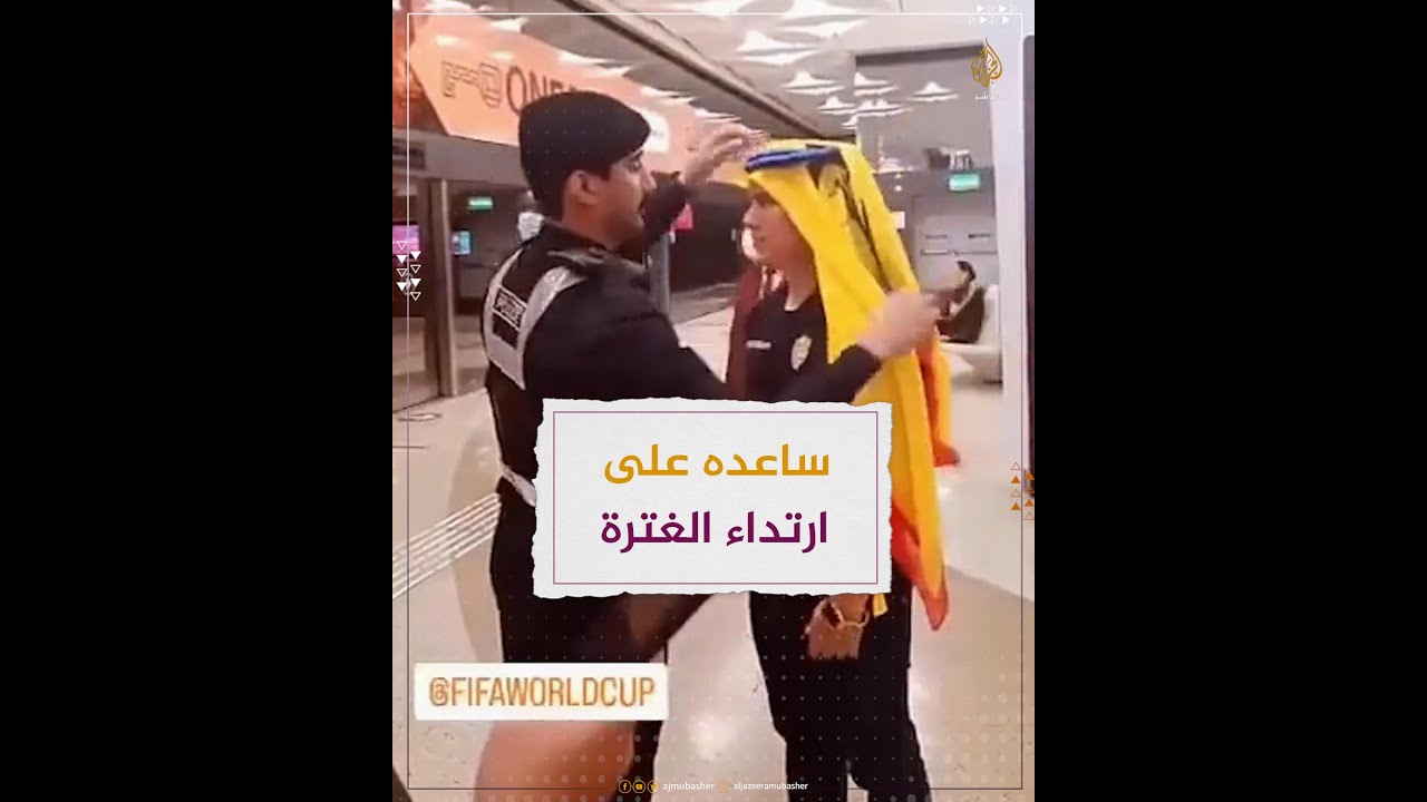 شرطي في قطر يساعد مشجعًا على ارتداء الغترة