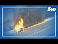 Raw: Flames from car fire spread along I-405 shoulder in Bellevue