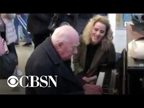 Singer spontaneously stops to perform with 91-year-old piano player in train station