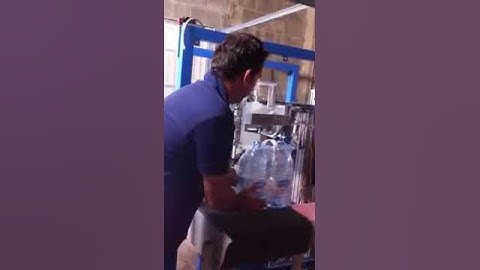 Automatic machine for positioning carrying handles