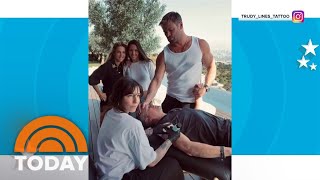 Chris Hemsworth holds Matt Damon's hand as he gets a tattoo