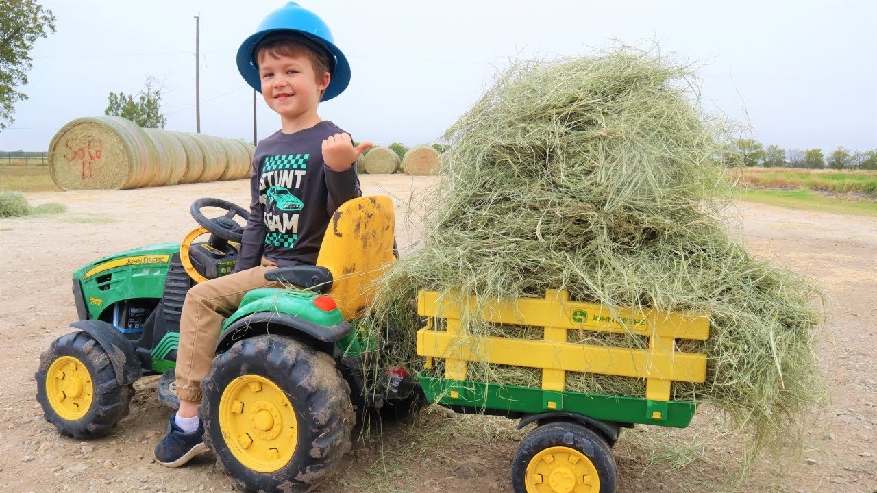 Using real tractors on the farm to work with hay and fix a tire