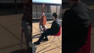 mentor gives student guitar