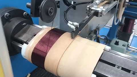 Automatic transformer coil winding machine with paper strip winding
