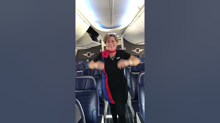 Flight Attendant closes overhead bin with feet