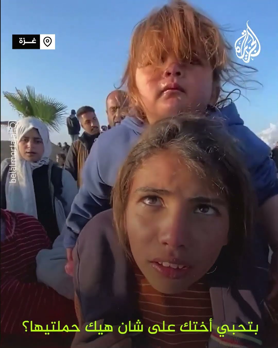 طفلة تحمل أختها على ظهرها في طريق العودة إلى شمال غزة