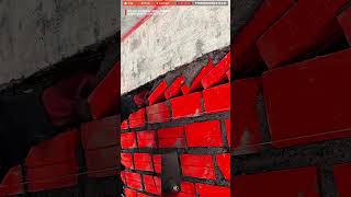 Experienced Worker Process Installing Angled Bricks Beneath A Concrete Beam
