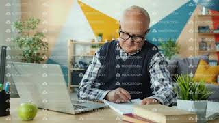 Elderly man using laptop computer typing going online taking notes at home
