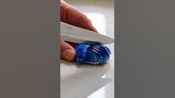 Blue sapphire shaped like a seashell sliced by sharp knife